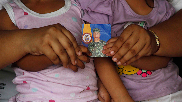 Las hijas del militar y quien era su esposa muestran la fotografía de Cárdenas Ramírez con el uniforme.