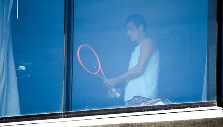 El tenista australiano Bernard Tomic se ejercita en su habitación de hotel en Melbourne el 17 de enero de 2021, mientras los jugadores se ponen en cuarentena en hoteles antes del torneo de tenis del Abierto de Australia.  Foto: AFP