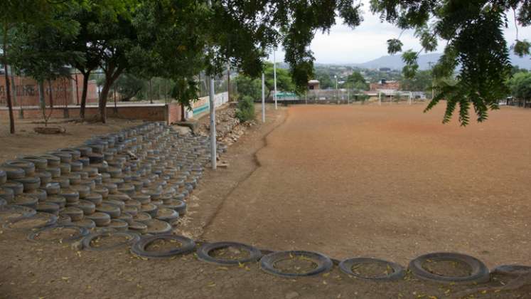 Gradería de llantas en la cancha de tierra del barrio. 