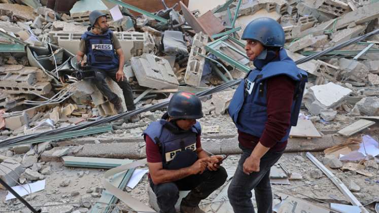 Los periodistas se sientan sobre los escombros de la Torre Jala, que albergaba oficinas de prensa internacionales, luego de un ataque aéreo israelí en la Franja de Gaza. Un ataque aéreo israelí demolió el edificio de 13 pisos que alberga la televisión Al-Jazeera con sede en Qatar y de la Agencia de noticias estadounidense The Associated Press. / Foto: AFP