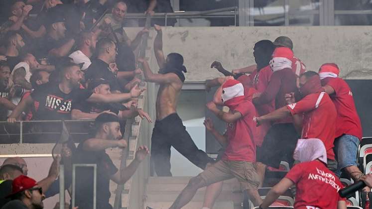 Los hinchas del Colonia (de rojo) provocan a los barristas del equipo francés.