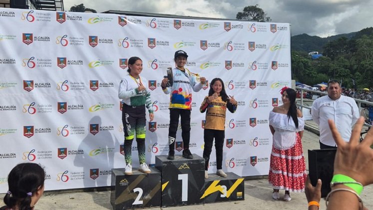 Camila de Hoz (centro) posa con el trofeo y el buso de campeona nacional.