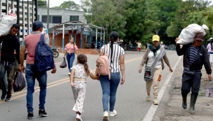 Personas cruzan a pie en el bloqueo vial.