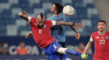 Arturo Vidal, mediocampista de Chile disputa el balón ante un defensor de Uruguay.