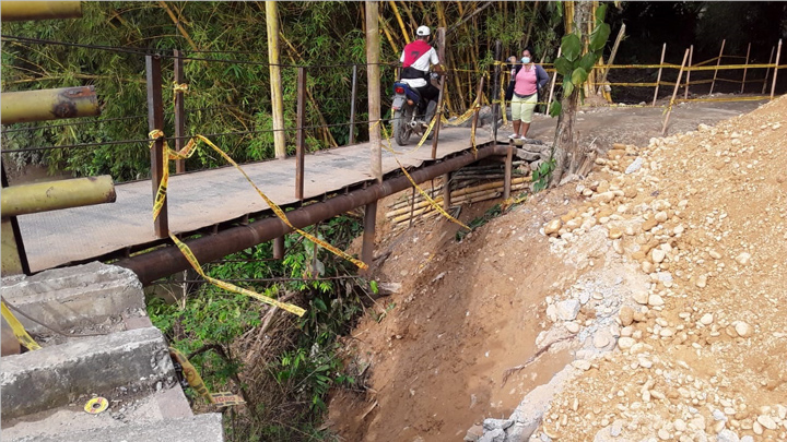 A través de un puente improvisado los habitantes pueden entrar y salir de sus veredas. 