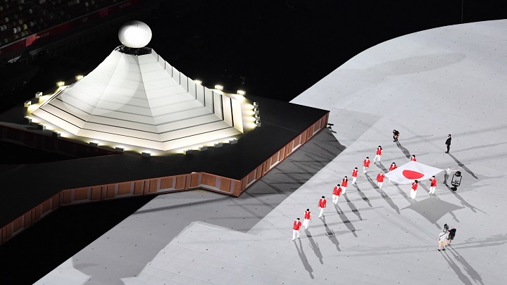 Un resumen muestra la bandera nacional japonesa que se lleva al campo de juego durante la ceremonia de apertura./Foto: AFP