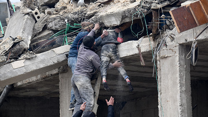 Los residentes recuperan a una niña herida de los escombros de un edificio derrumbado./Foto: AFP