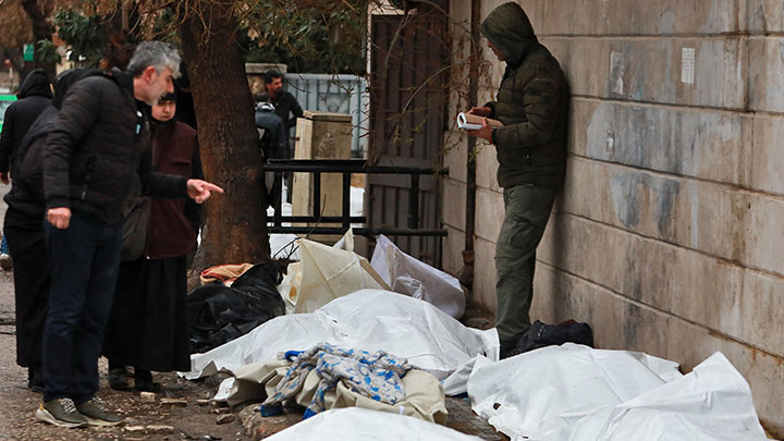 Los sirios revisan los cuerpos cubiertos con plástico que yacen en la calle frente a una morgue en la ciudad de Alepo./Foto: AFP