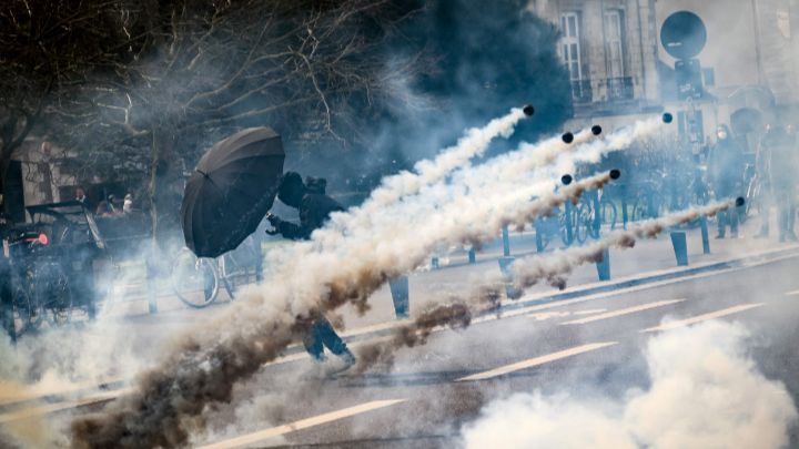 Francia-Un ciudadano sostiene un paraguas para protegerse de los gases lacrimógenos, durante las manifestaciones en Nantes contra la reforma de las pensiones propuesta por el gobierno, el 15 de marzo.