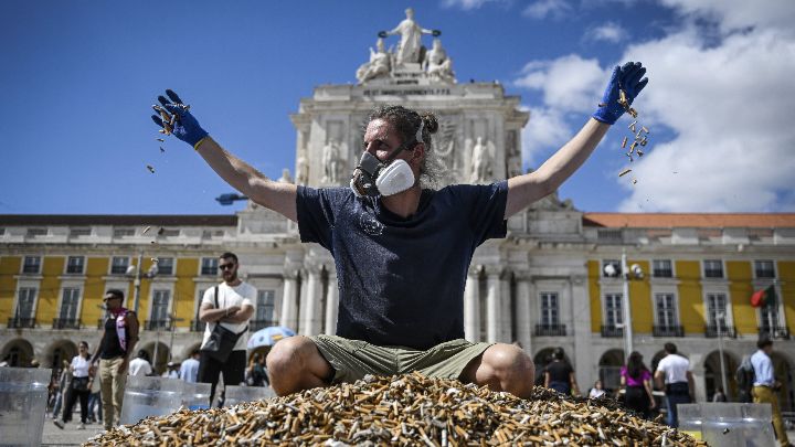 Portugal-Activista medioambiental arroja colillas de cigarrillos como acto de protesta en la plaza del Comercio de Lisboa el 23 de abril.