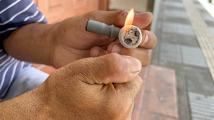 Hombre prepara pipa de basuco.