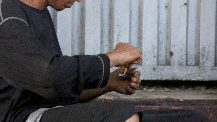 Hombre prepara droga para consumirla.
