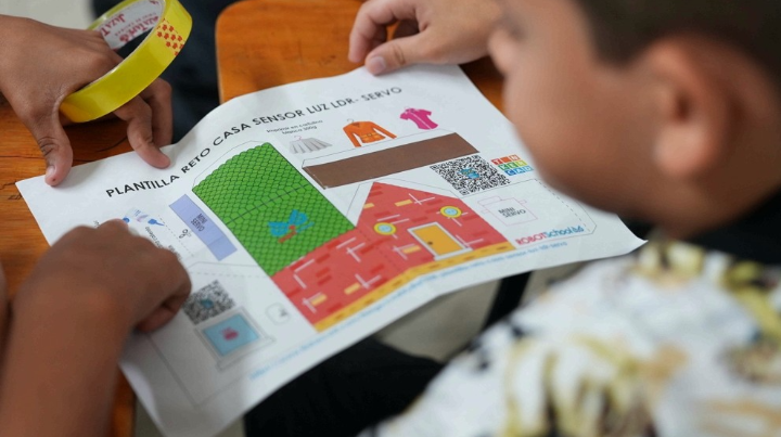 Un niño recibe indicaciones de un maestro en Escuela Temporal para La Paz. 