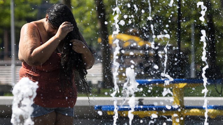 persona se baña en plaza por el calor