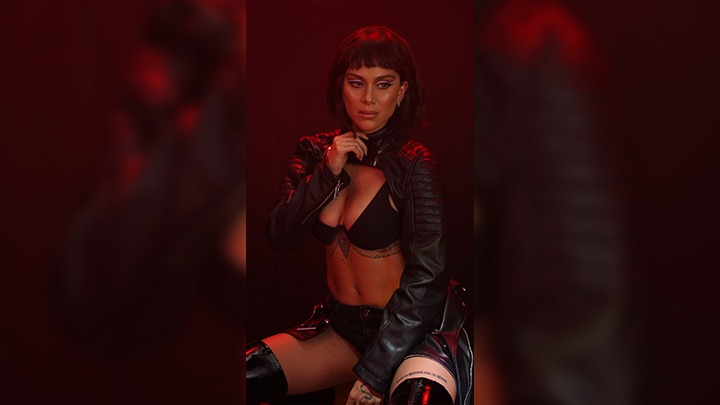 Con su abdomen pronunciado, un crop top tipo bikini, manga larga y un pantalón negro, la cantante anunció el nuevo disco. 