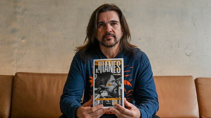 Juanes y el libro sobre su vida. /AFP