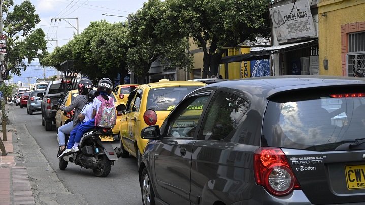 Algunos motorizados esquivan los carros, arriesgándose.
