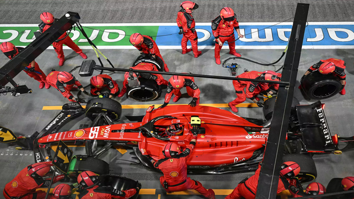 Mecánicos se afanan en el cambio de ruedas del Ferrari del piloto español Carlos Sainz Jr durante el GP de Singapur el 17 de septiembre de 2023. © MOHD RASFAN / AFP