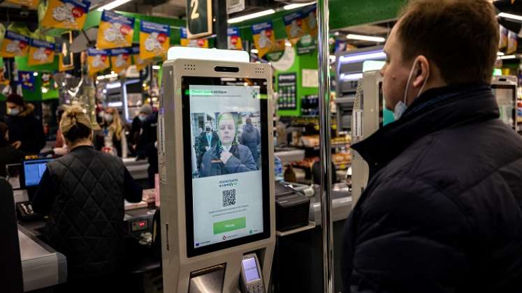 Bajarse la mascarilla, mirar a la cámara, y ya las compras están pagadas. / Foto: AFP