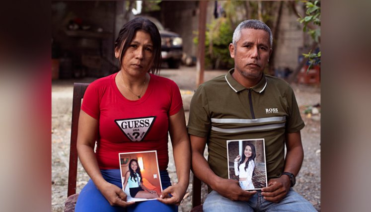 Mileidys Torrealba y Eduard José Falcón posan con retratos de su hija Eduarlis Falcón (20) quien fue asesinada en el poblado de La Misión, estado Portuguesa./ Foto: AFP