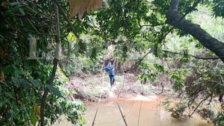 Ante la falta de un puente, en la vereda La Llana de Tibú sus habitantes cruzan sobre las cuerdas que aún quedan de la estructura. / Foto: Cortesía