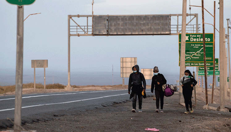 Algunos esperan un ‘aventón’ de los transportadores que cruzan el desierto con sus vehículos de carga.