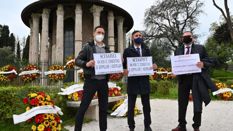 Trabajadores de las funerarias sostienen carteles que dicen: "Disculpas, pero no nos dejan enterrar a tus seres queridos", mientras protestan en el antiguo templo circular romano contra la interrupción de los servicios funerarios debido al creciente número de muertes causadas por la COVID-19. / Foto: AFP