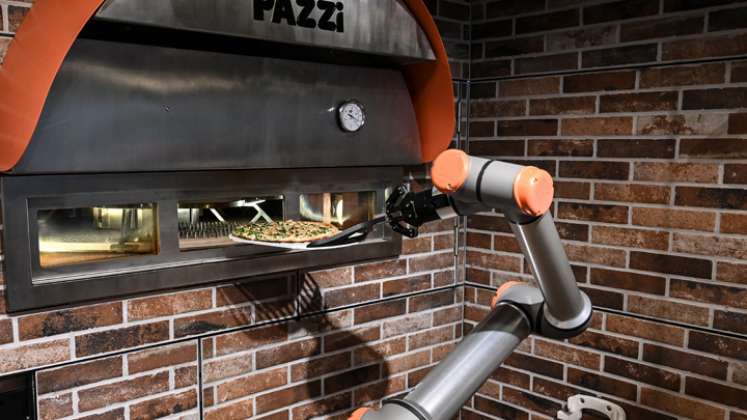 El robot para hacer pizzas de la startup parisina Pazzi, que comenzó a operar en el corazón de París, puede ser el precursor de un ejército de futuros robots cocineros en todo el mundo. El pequeño restaurante Pazzi, en el distrito de Beaubourg, es el segundo en abrir, después del centro comercial Val d'Europe, que abrió en noviembre de 2019. / Foto: AFP