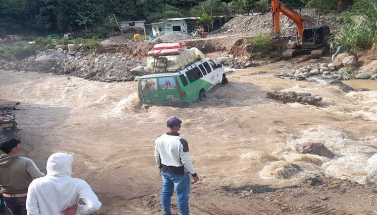 Desafiando las corrientes de agua que bajan de las montañas los labriegos exponen sus vidas para salir de la zona.