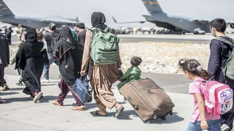 Un niño mira el avión mientras se dirige hacia su vuelo durante una evacuación en el Aeropuerto Internacional Hamid Karzai, Kabul. / AFP