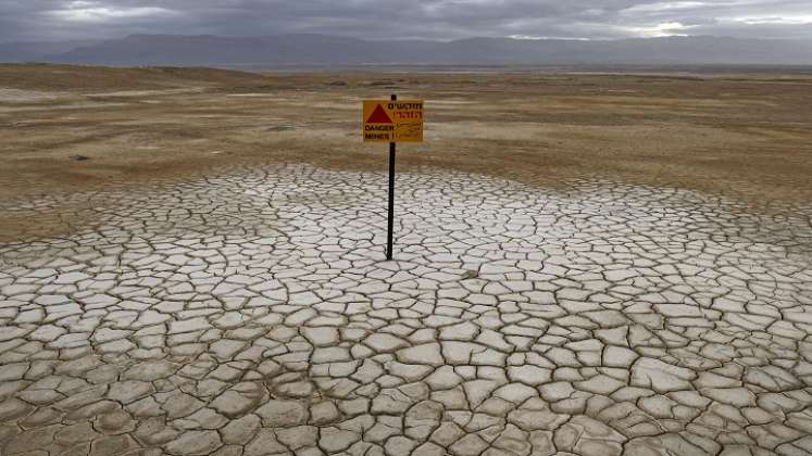 los tres kilómetros de arena rocosa que separan el spa de la orilla están hoy salpicados de agujeros y grietas./ AFP