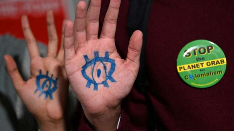 Los activistas climáticos y los delegados participan en una manifestación frente a una sala antes de una sesión plenaria durante la Conferencia de las Naciones Unidas sobre el Cambio Climático COP26 en Glasgow este jueves. / Foto: AFP