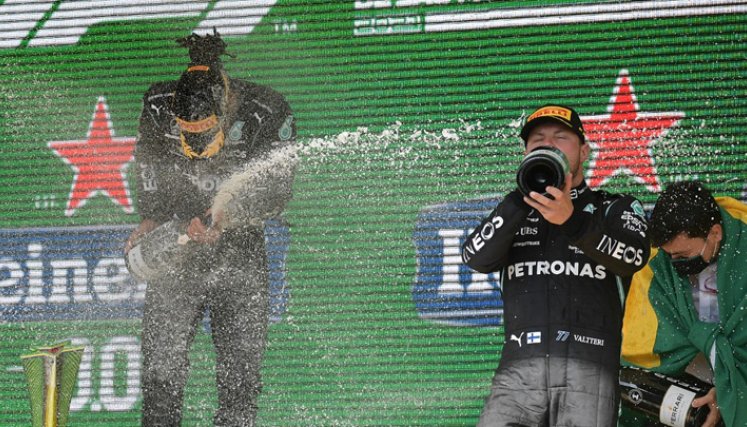 El piloto británico de Mercedes, Lewis Hamilton (izquierda), y el finlandés de Mercedes, Valtteri Bottas (derecha), celebran en el podio tras obtener la primera y tercera posición, respectivamente, en el Gran Premio de Fórmula Uno de Sao Paulo de Brasil. / Foto: AFP