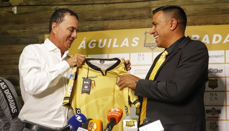 César Farías (derecha), exhibe la camiseta de Águilas Doradas nuevo equipo.