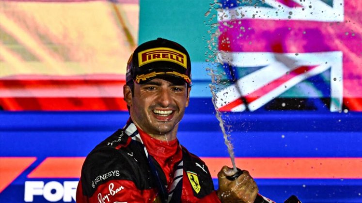 El piloto español de Ferrari Carlos Sainz Jr celebrá con champán desde el podio su victoria en el GP de Singapur de F1, el 17 de septiembre de 2023. Foto: Lillian SUWANRUMPHA / AFP