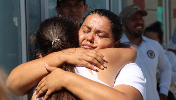 Nubia Misse, familiar de colombiano detenido, se abraza con una joven en medio de la emoción por la liberación. 