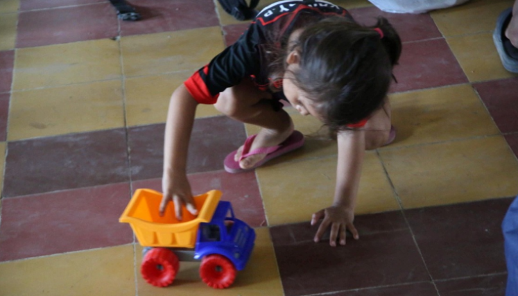 Una niña juega con una volqueta de juguete en un refugio en Catatumbo.