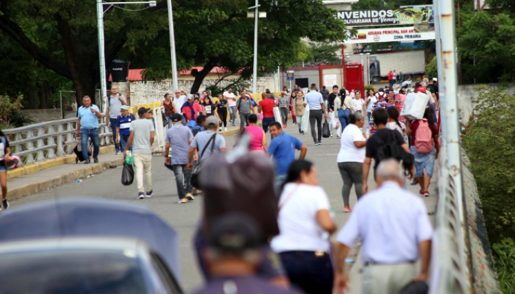 Personas caminan por el puente Simón Bolívar, bloqueado por la protesta.