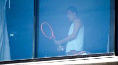 El tenista australiano Bernard Tomic se ejercita en su habitación de hotel en Melbourne el 17 de enero de 2021, mientras los jugadores se ponen en cuarentena en hoteles antes del torneo de tenis del Abierto de Australia.  Foto: AFP