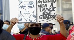 Un partidario del gobierno venezolano liderado por el presidente Nicolás Maduro sostiene una señal contra el líder opositor Juan Guaidó, frente a la Asamblea Nacional.