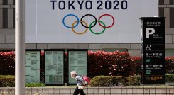Una anciana pasa junto a una pancarta oficial de los Juegos Olímpicos de Tokio 2020 en el edificio del gobierno metropolitano de Tokio.