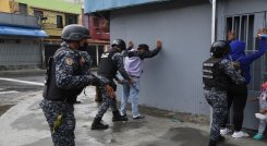 Miembros de la Policía Nacional Bolivariana requisan a personas durante enfrentamientos con presuntos integrantes de una banda criminal./Foto: AFP