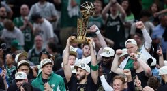Jayson Tatum la estrella de los Celtics levanta el trofeo de campeón.