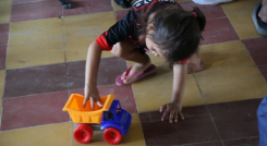Una niña juega con una volqueta de juguete en un refugio en Catatumbo.