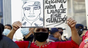 Un partidario del gobierno venezolano liderado por el presidente Nicolás Maduro sostiene una señal contra el líder opositor Juan Guaidó, frente a la Asamblea Nacional.
