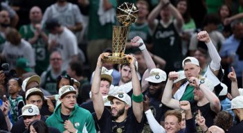 Jayson Tatum la estrella de los Celtics levanta el trofeo de campeón.