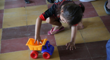 Una niña juega con una volqueta de juguete en un refugio en Catatumbo.